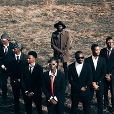A group of adult men standing together outdoors.