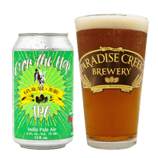 A pint of India pale ale beside hop cones