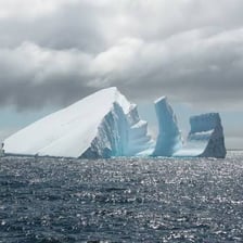 A large iceberg floating in the ocean.
