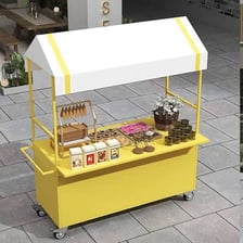 Small merchant kiosks arranged in an outdoor market.