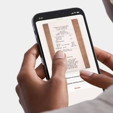 A person paying an expense while holding a receipt.