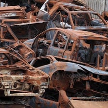 An old car covered in reddish-brown rust