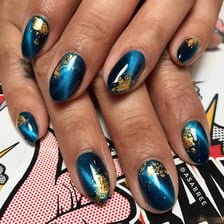 A hand displaying colorful manicure nail art.