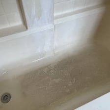 White soap scum visible along the inside of a bathtub