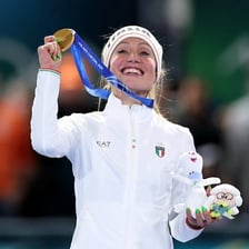 A gold Olympic medal displayed in an Italian Olympic setting.