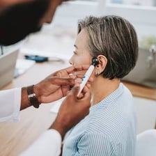 An ear, nose, and throat specialist examining a patient.
