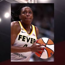 A basketball player holding a ball on a court