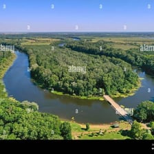An aerial view of a U-shaped oxbow lake beside a river