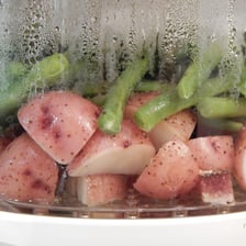 Steam and aroma rising from a freshly cooked dish in a kitchen.