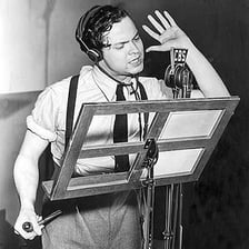 Actors recording a radio drama around studio microphones.