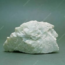 A pale talc mineral sample beside fine talc powder.