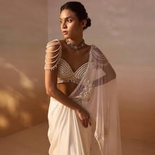 A person wearing a traditionally draped South Asian sari.