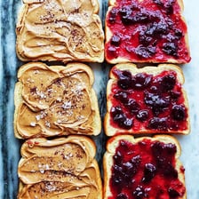 Peanut butter and jelly being spread on bread