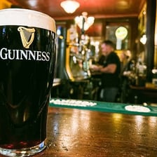 A pint of Guinness on a pub bar.