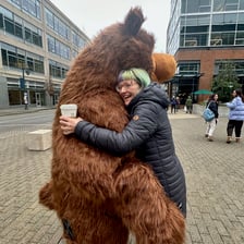 Two people embracing in a tight bear hug.