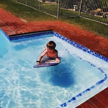 A person briefly entering a swimming pool for a quick dip.