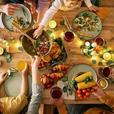 People sharing a large meal around a dinner table.