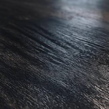 A close-up showing the nearly black grain of ebony wood