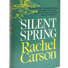A copy of Silent Spring beside a pesticide warning symbol