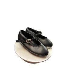 A pair of black tap shoes with metal plates on the soles.