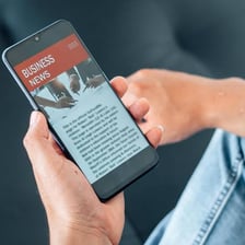 A person checking current news on a phone.