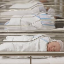 A newborn resting in a nursery bassinet