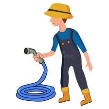 A person washing an object with water from a garden hose.