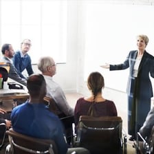 A labor representative speaking with workers at a meeting.