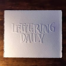 Raised lettering visibly embossed on paper