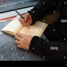 A person marking a planned route on a map