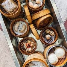 A restaurant cart laden with steaming dim sum dishes