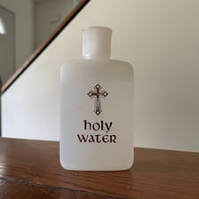 A small vial of holy water beside a church.