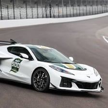 A pace car leading race cars around an oval track