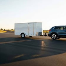 A vehicle towing a trailer along a road