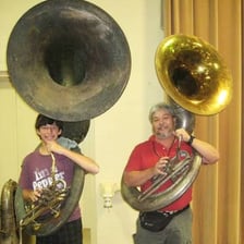 A brass tuba with its large bell facing upward.