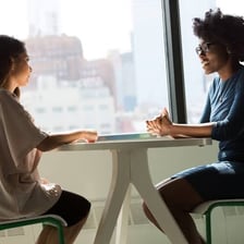 Two people smiling and agreeing during a conversation.