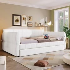 A daybed arranged as a sofa with cushions.
