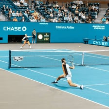 Two tennis players exchanging shots during a rally.