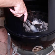 Gray ash collected beneath a charcoal grill