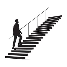 A person moving upward on a staircase.