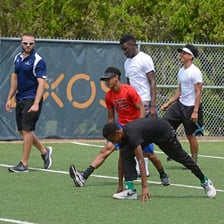 A coach demonstrating a technique to athletes at a sports clinic