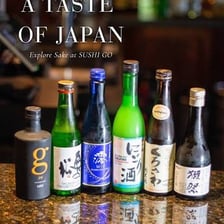 Bottles of sake are displayed at a sushi bar.