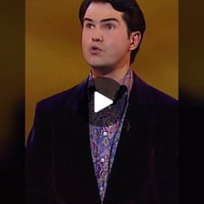 A comedian delivering a dry, deadpan humorous performance.