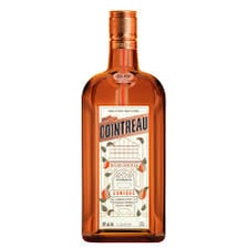 A bottle and glass of orange-flavored triple sec liqueur