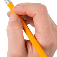 A hand erasing pencil writing from paper