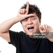 A person with a visibly mocking expression while laughing.