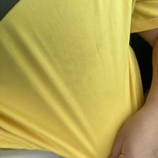 A person looking at a visible spot on clothing.
