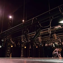 A performer presenting an act on a theater stage.