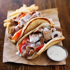 A lamb gyro wrapped in pita and served with tzatziki.