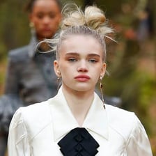 A person wearing a loosely arranged messy bun hairstyle